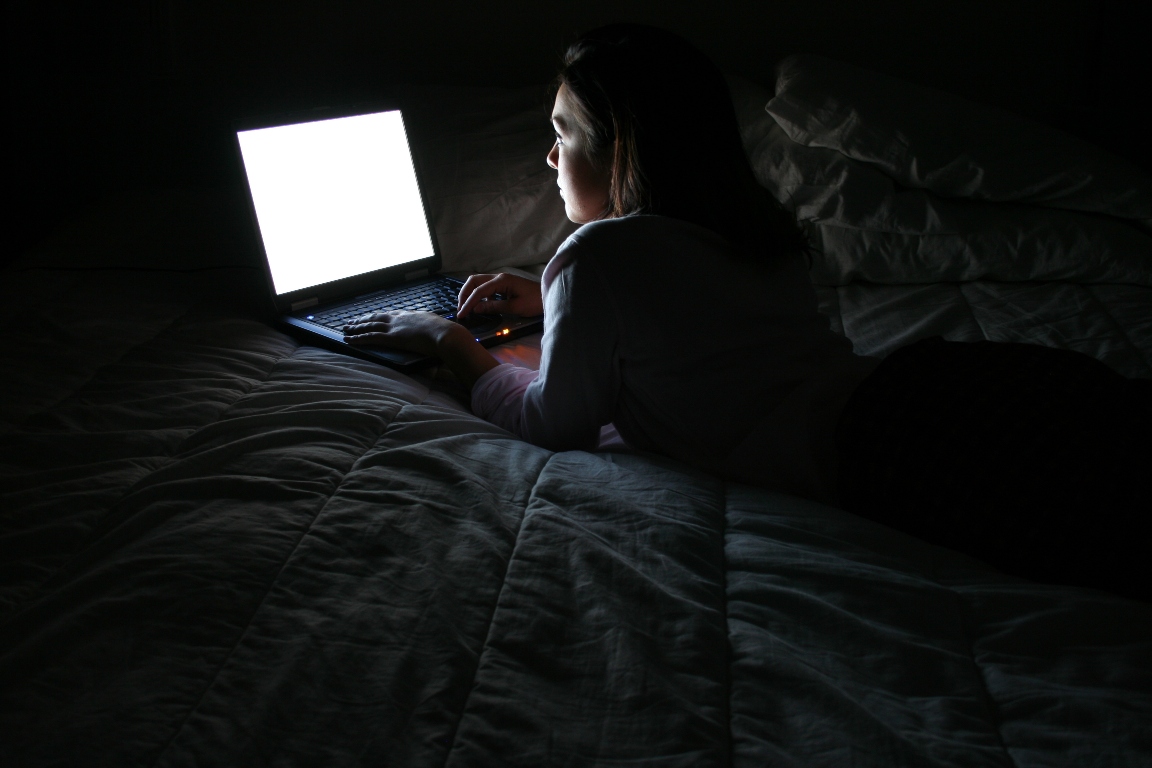 Девушка за компьютером в темноте